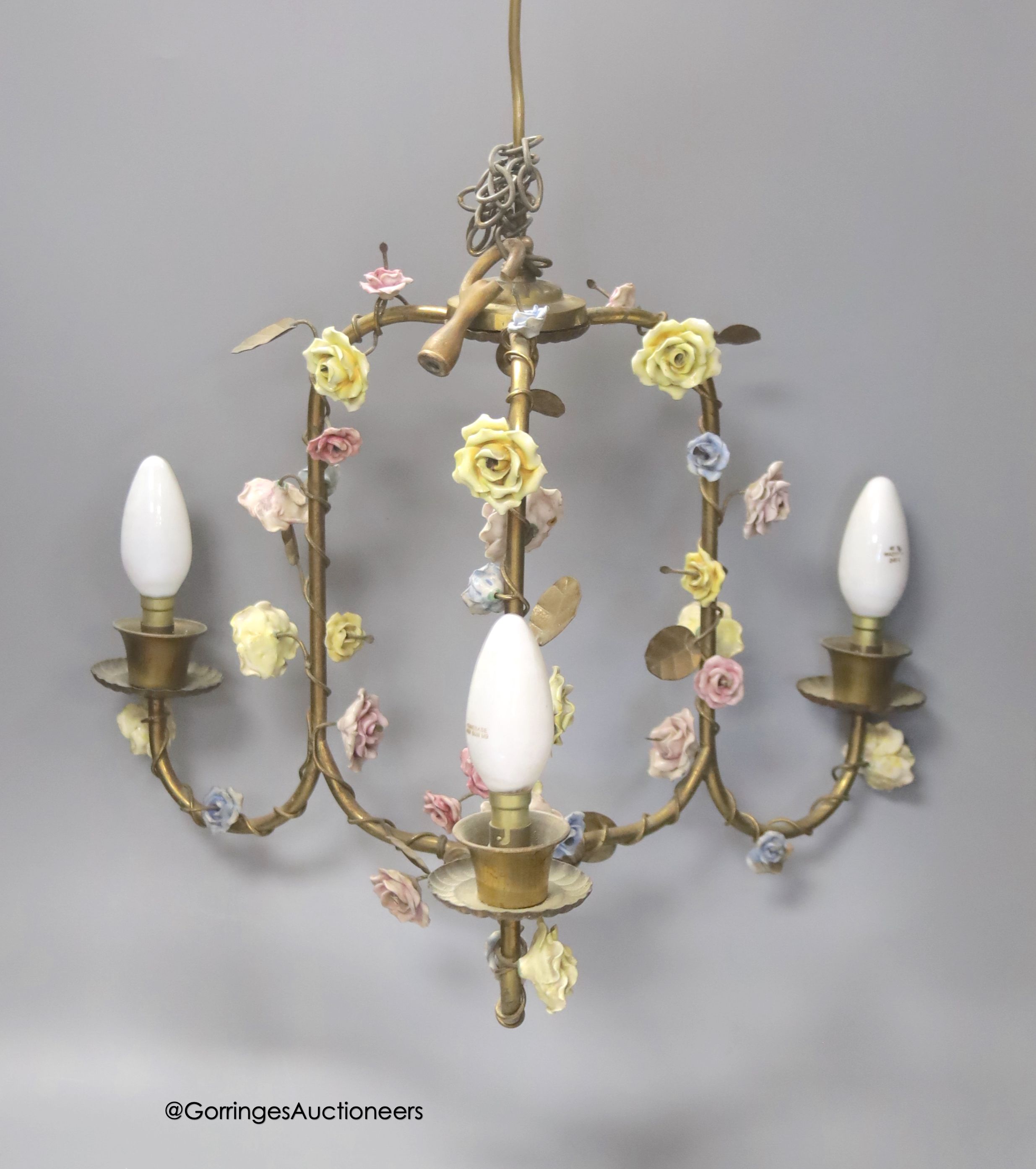 A floral encrusted brass three light ceiling fitting, width 40cm